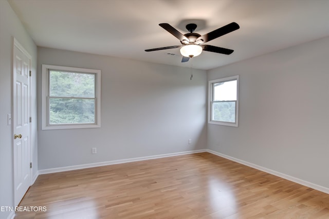 empty room with ceiling fan and light hardwood / wood-style flooring