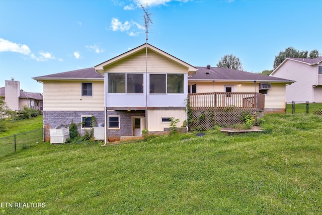 back of house featuring a wooden deck, a yard, a wall mounted air conditioner, and a sunroom