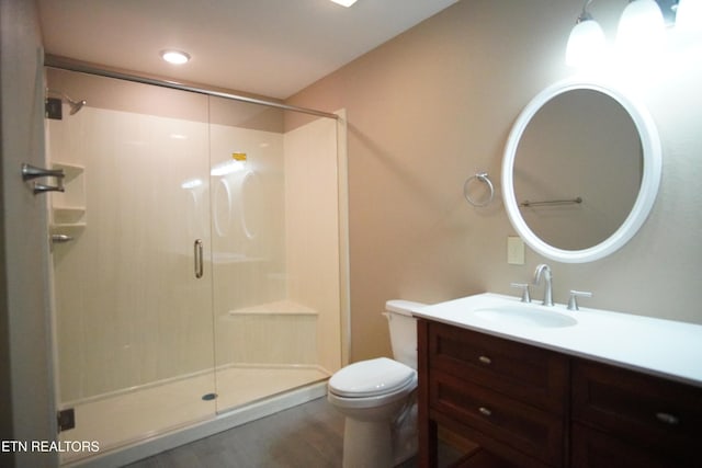 bathroom featuring hardwood / wood-style flooring, toilet, vanity, and a shower with shower door