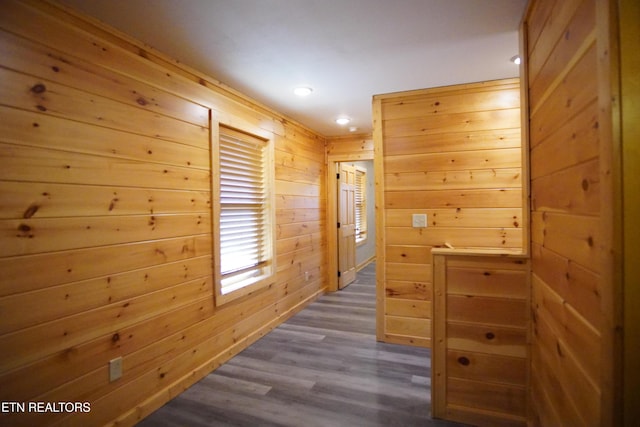 hall with dark hardwood / wood-style flooring and wood walls