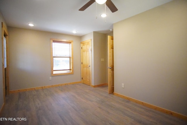 spare room with dark wood-type flooring and ceiling fan