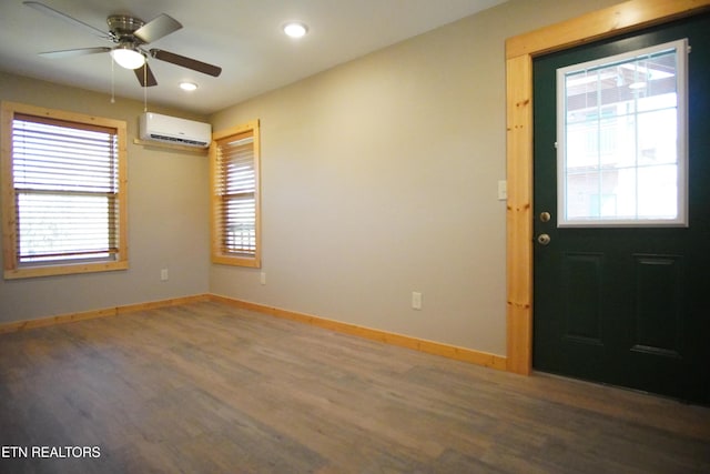 foyer entrance featuring an AC wall unit, dark hardwood / wood-style floors, and ceiling fan