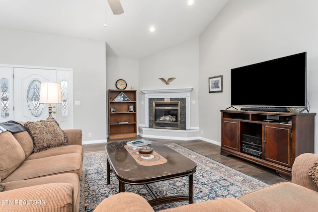 living room featuring ceiling fan, lofted ceiling, a high end fireplace, and dark hardwood / wood-style flooring