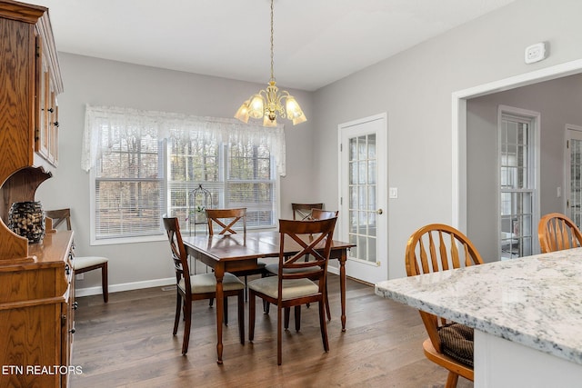 dining room with dark hardwood / wood-style floors and a notable chandelier