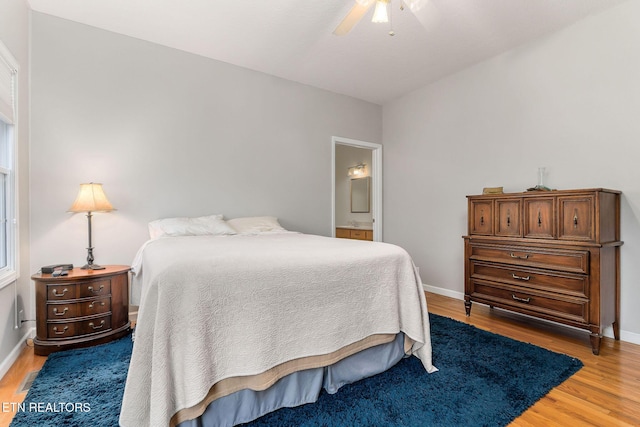 bedroom with hardwood / wood-style flooring, ensuite bath, and ceiling fan