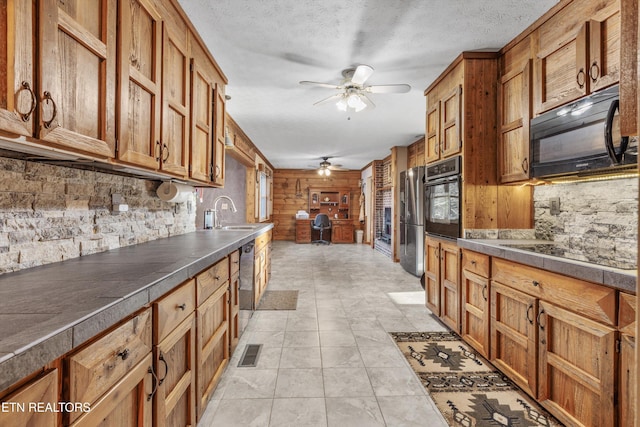 kitchen with sink, backsplash, ceiling fan, black appliances, and a textured ceiling