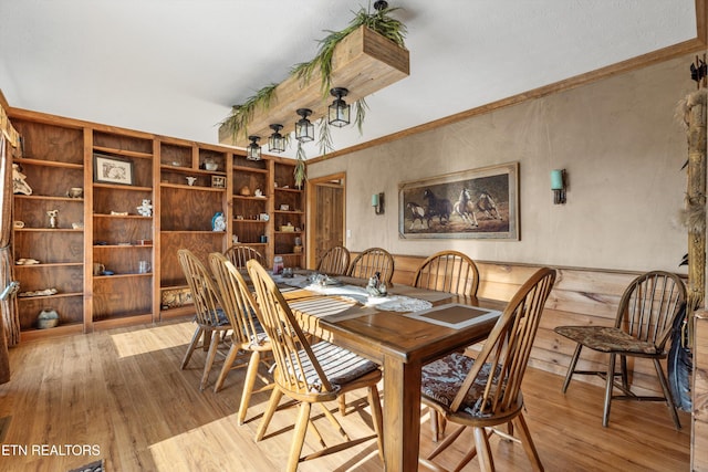 dining area featuring crown molding and light hardwood / wood-style flooring