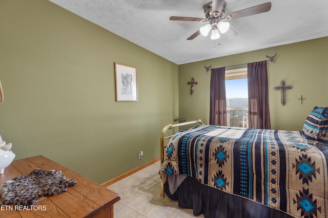 bedroom featuring light tile patterned floors, a textured ceiling, and ceiling fan