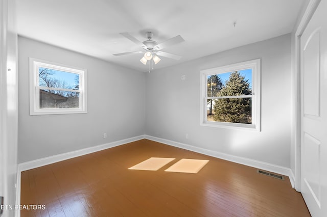 empty room with dark hardwood / wood-style floors and ceiling fan