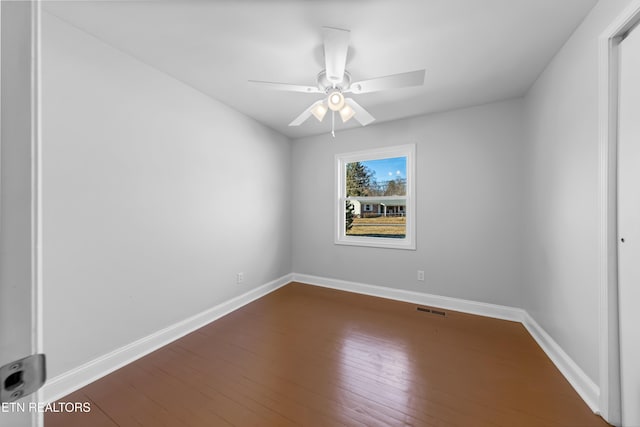 empty room featuring dark wood-type flooring and ceiling fan