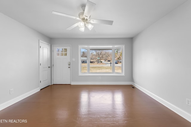 empty room with ceiling fan and dark hardwood / wood-style flooring