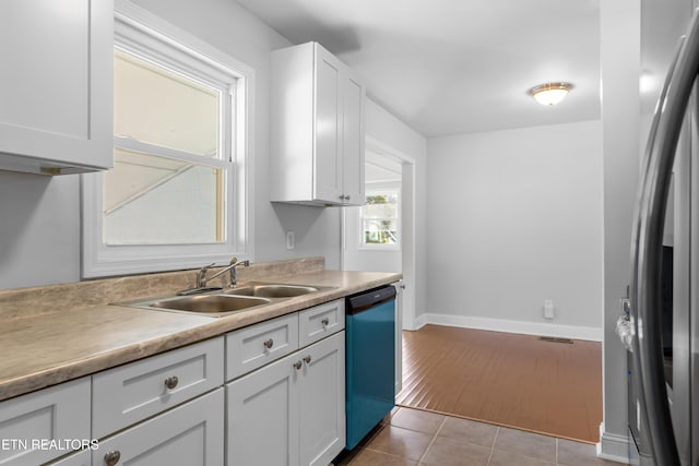 kitchen with white cabinetry, stainless steel appliances, sink, and light tile patterned floors