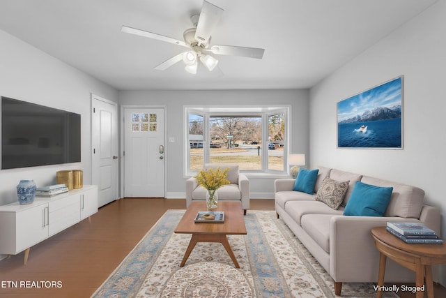 living room with ceiling fan and dark hardwood / wood-style flooring