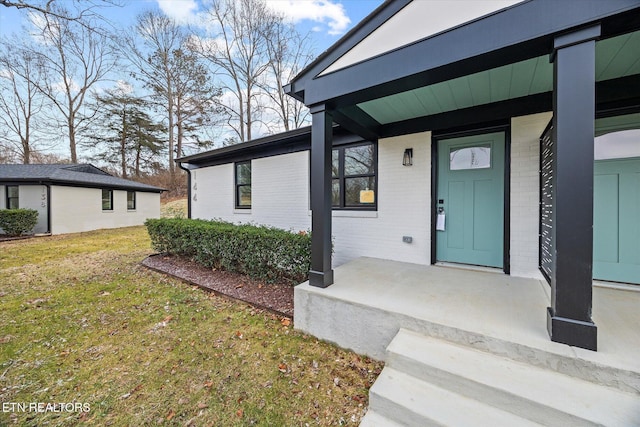 property entrance featuring covered porch and a lawn