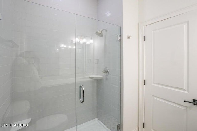 bathroom featuring toilet and an enclosed shower