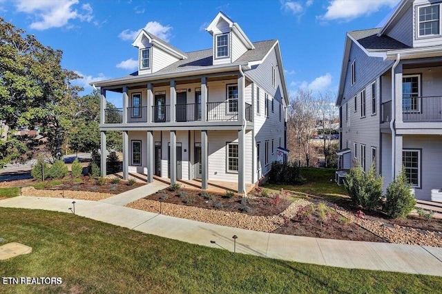 view of front of home with a balcony and a front lawn