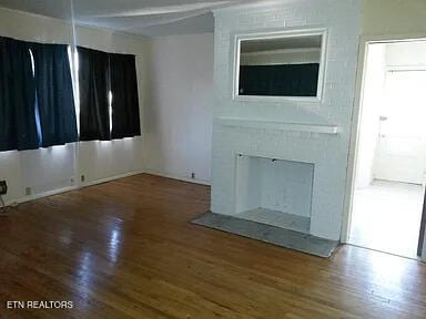 unfurnished living room featuring hardwood / wood-style flooring and a fireplace