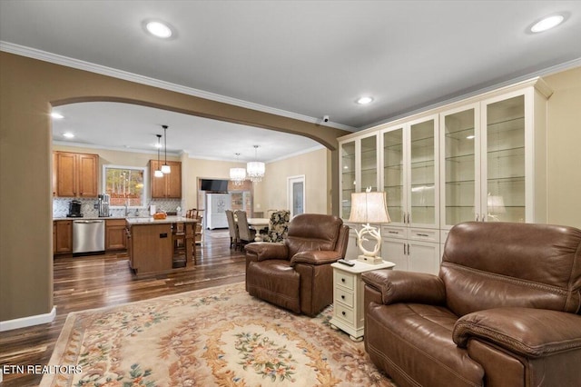 living room featuring hardwood / wood-style flooring, ornamental molding, and a chandelier