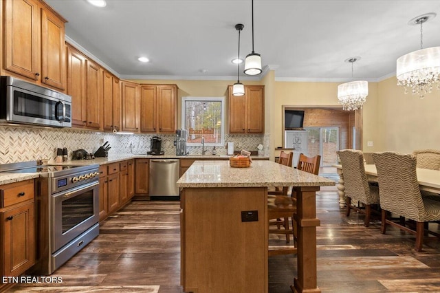 kitchen featuring decorative light fixtures, appliances with stainless steel finishes, dark hardwood / wood-style flooring, a kitchen breakfast bar, and a kitchen island