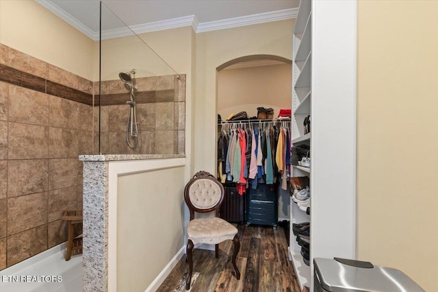 bathroom featuring hardwood / wood-style floors, ornamental molding, and a tile shower