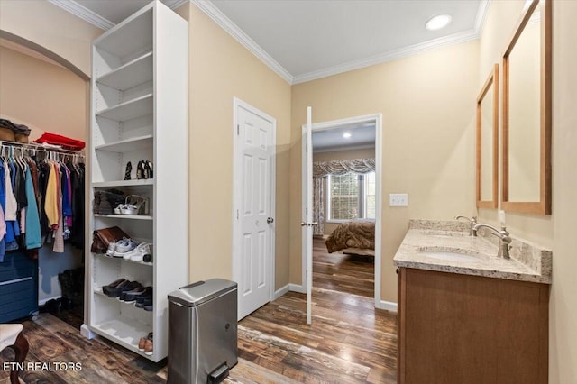 bathroom featuring hardwood / wood-style flooring, ornamental molding, and vanity