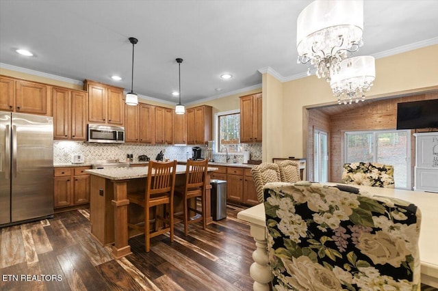 kitchen featuring hanging light fixtures, backsplash, dark wood-type flooring, and appliances with stainless steel finishes