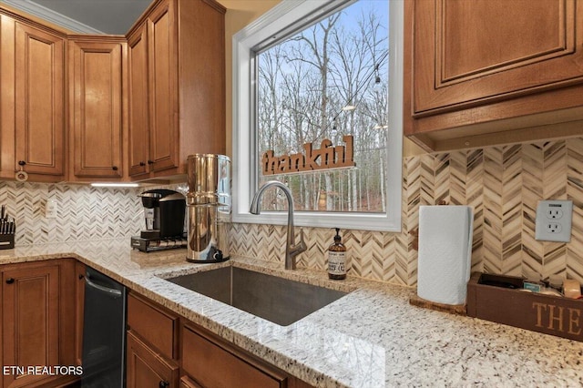 kitchen with sink, light stone counters, tasteful backsplash, plenty of natural light, and dishwasher