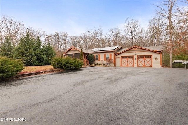 view of front of house with a garage and solar panels