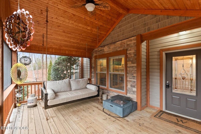 sunroom featuring lofted ceiling, ceiling fan with notable chandelier, and wood ceiling