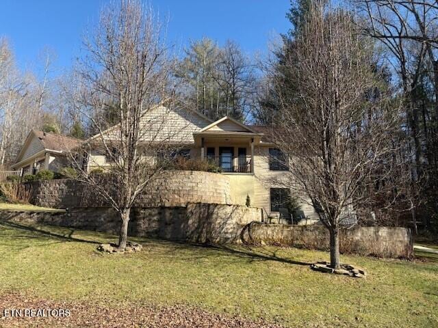 view of front of property with a front yard and a balcony