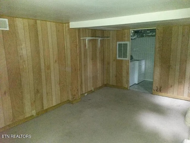 spare room with wooden walls and washing machine and dryer