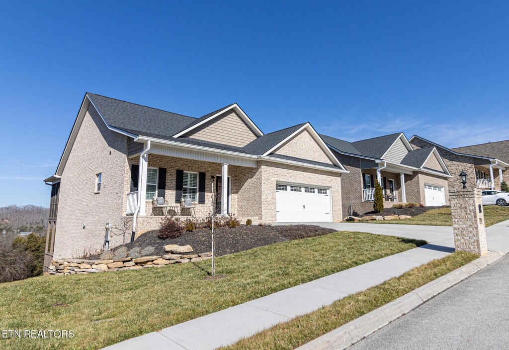 577 Timberline Dr, Lenoir City, TN 37772 - craftsman-style house featuring a garage, a front lawn, and covered porch