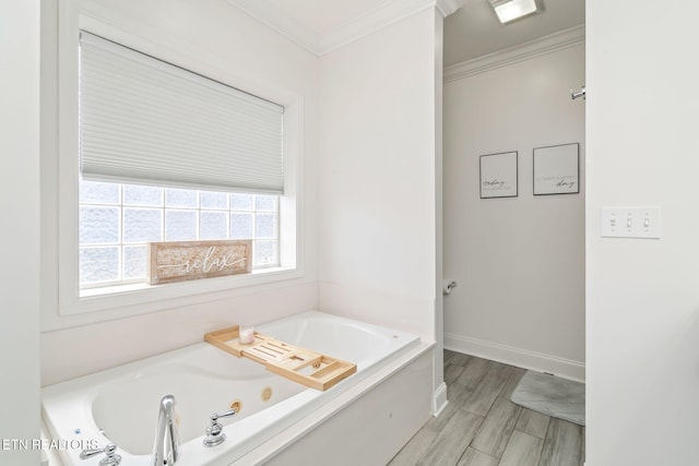 bathroom with crown molding, wood finished floors, a tub with jets, and baseboards