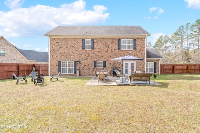 back of house with a patio, a fenced backyard, a yard, a fire pit, and brick siding