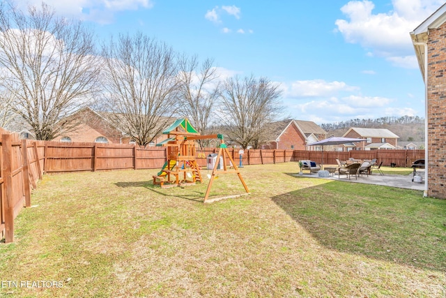 view of yard with a fenced backyard, a playground, and a patio