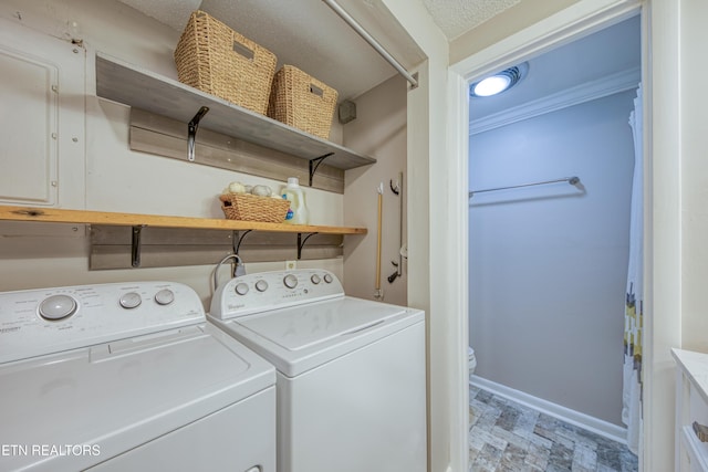 washroom featuring washing machine and dryer, crown molding, and a textured ceiling