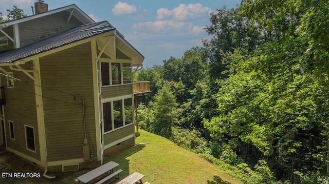 view of side of home with a balcony and a lawn