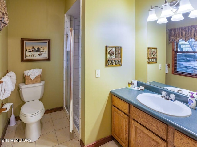 bathroom featuring toilet, vanity, a shower with door, and tile patterned flooring