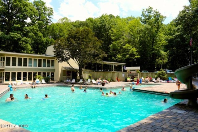 view of swimming pool with a patio area and a water slide