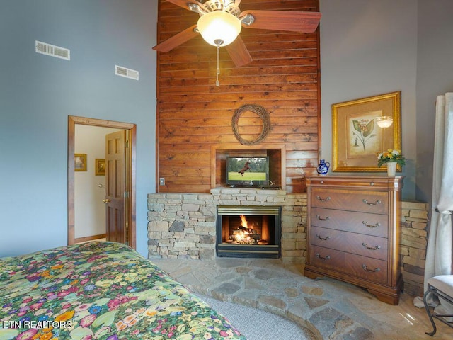 carpeted bedroom with ceiling fan, a fireplace, and high vaulted ceiling