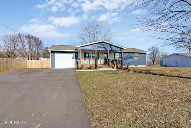 ranch-style home featuring a porch, a garage, and a front yard