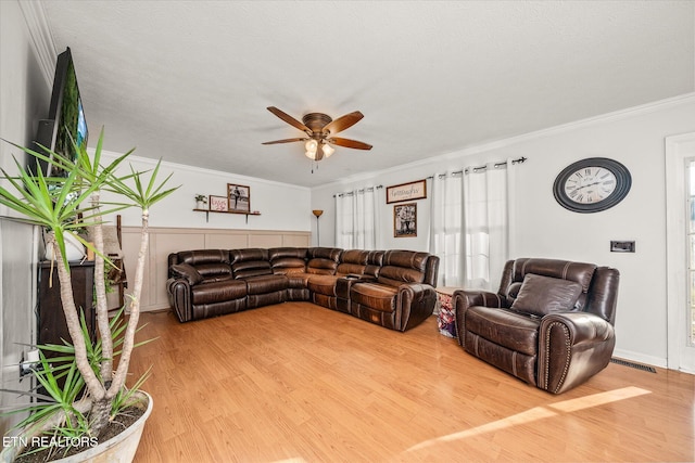 living room with crown molding, ceiling fan, a textured ceiling, and hardwood / wood-style flooring