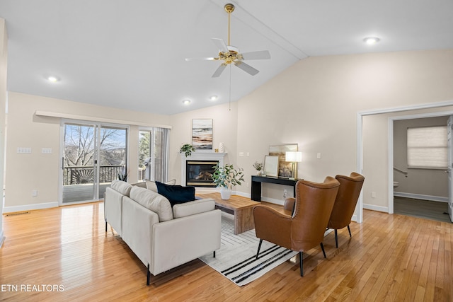 living room with ceiling fan, lofted ceiling, and light wood-type flooring