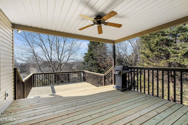 wooden deck with ceiling fan and area for grilling