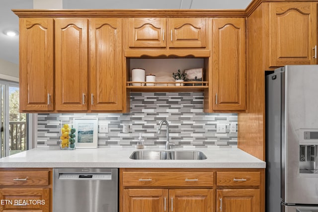 kitchen with tasteful backsplash, appliances with stainless steel finishes, and sink