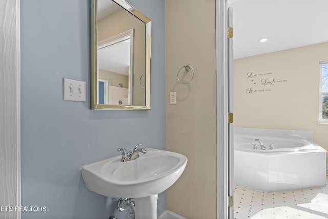 bathroom featuring sink and a washtub