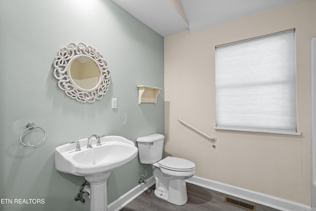 bathroom featuring wood-type flooring and toilet