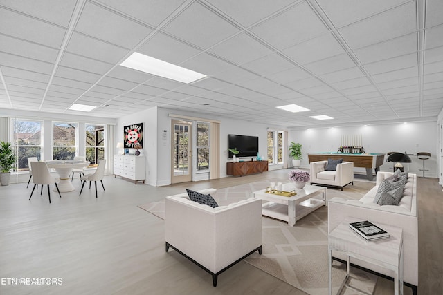 living room featuring a paneled ceiling and a wealth of natural light