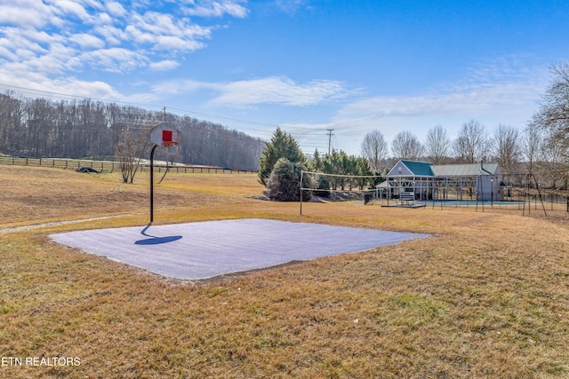 view of basketball court with a rural view, a yard, and a playground