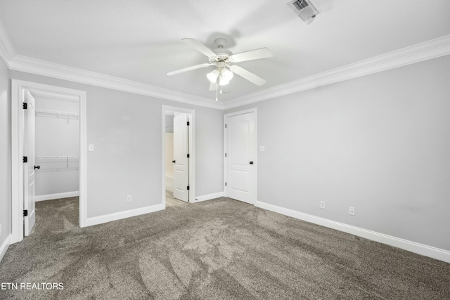 unfurnished bedroom with a spacious closet, carpet floors, ornamental molding, and a closet